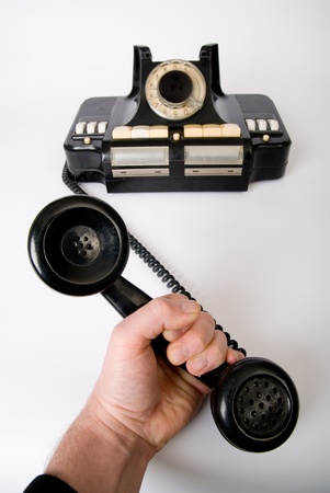 The hand holds a tube of old phoneの写真素材