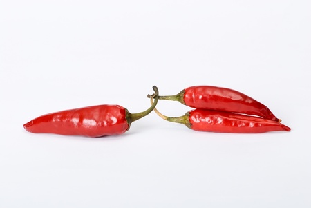 One red hot pepper against two pepperの写真素材