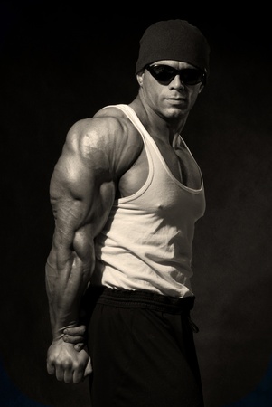 strong athletic man in dark glasses on a black backgroundの写真素材
