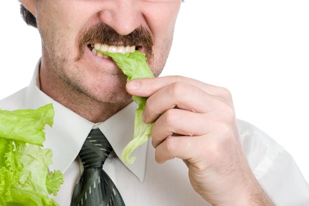 Man eats sheet of the salad. Isolated on white backgroundの写真素材