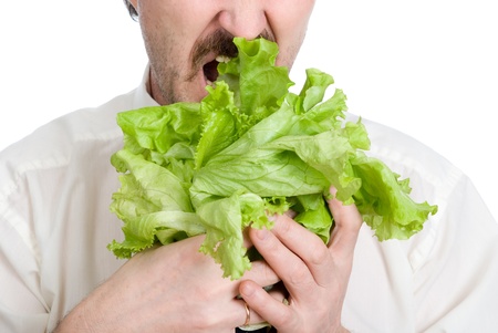 Man eats sheet of the salad. Isolated on white backgroundの写真素材