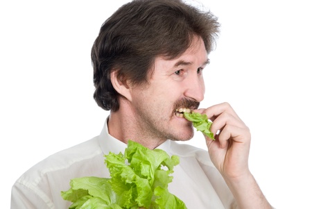 Man eats sheet of the salad. Isolated on white backgroundの写真素材