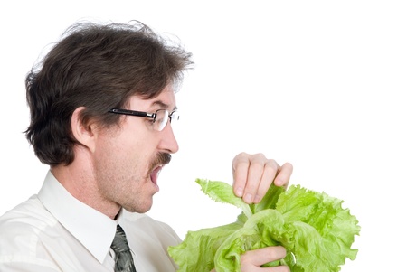 Man eats sheet of the salad. Isolated on white backgroundの写真素材