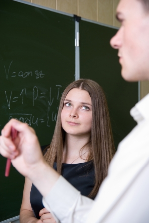 Beautiful girl attentively looks at partners. Costs at a boardの写真素材