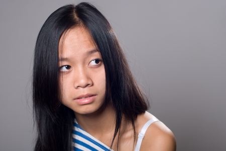 Portrait a close up of girl looking asidel.Asian girl isolated on gray backgroundの写真素材
