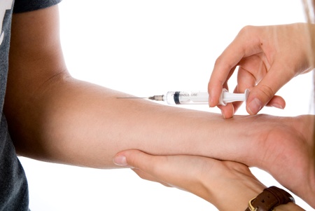 vaccine injection in hand isolated on whiteの写真素材
