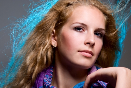 Close-up portrait of a beautiful girl. Hair illuminated with blue lightの写真素材