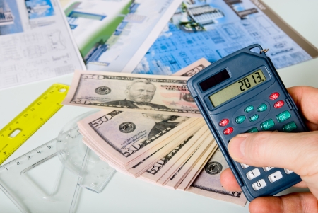 Calculator on a blurred background of the project and dollars.の写真素材
