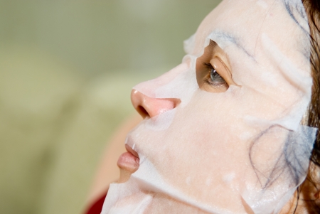 Portrait in Profile woman applying rejuvenating facial mask on her face.の写真素材