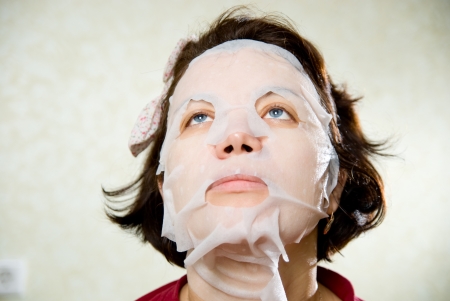 Closeup beauty portrait of woman with a mask on her face for treatment.の写真素材