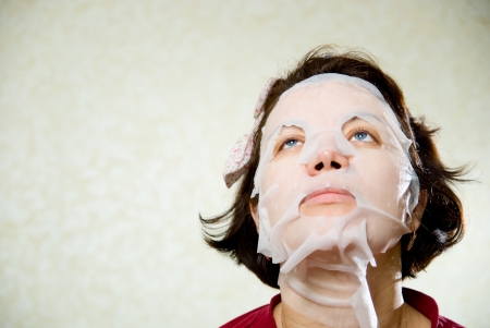 Closeup beauty portrait of woman with a mask on her face for treatment.の写真素材