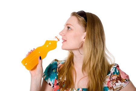 Portrait of a beautiful girl with a bottle of orange juice. Isolated on white backgroundの写真素材