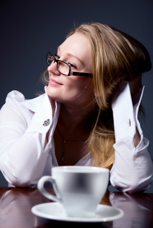 Thoughtful business woman with a cup of coffee.の写真素材