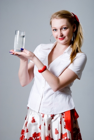 Portrait of a pretty young woman holding a glass of water.の写真素材