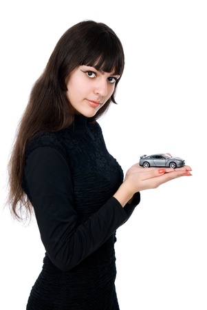 Portrait of young woman dreaming to purchase a new car against white background.の写真素材