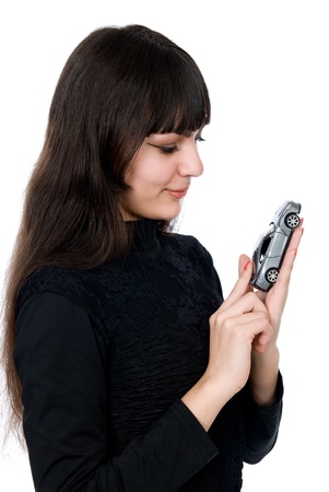 Portrait of a beautiful young woman dreaming to purchase a new car against white backgroundの写真素材