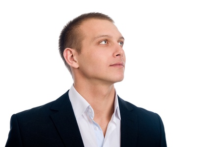 Close-up young businessman looking up, against isolated white backgroundの写真素材