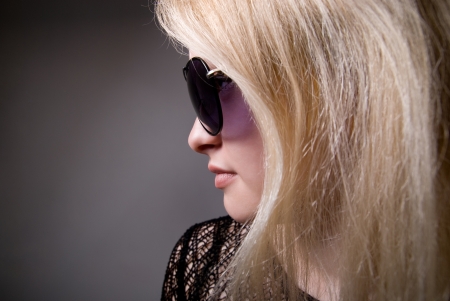 Profile of a woman in sunglasses on a gray backgroundの写真素材