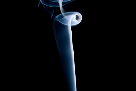 A pillar of blue smoke on a black background.の写真素材