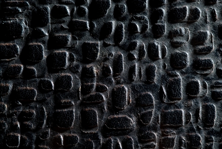 Old black leather with cutouts, background.