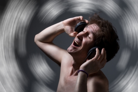 A man with a torso listening to music with headphones.の写真素材