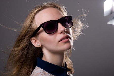 close-up portrait of a young girl in sunglasses on a gray backgroundの写真素材