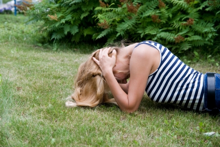 Girl lying on the grass and clutched his hands behind his head. The girl problemsの写真素材
