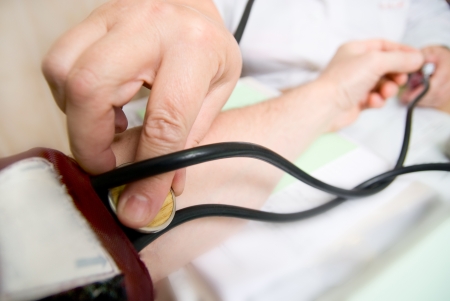 Doctor measures blood pressure in a patient.の写真素材