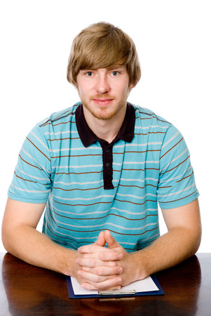 Portrait of a young man sitting behind a desk. isolated on white backgroundの写真素材