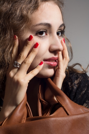 Portrait of a beautiful pensive girl with hands on face.の写真素材