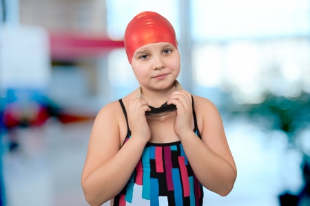 Portrait of a young girl in a red cap at the pool.の写真素材