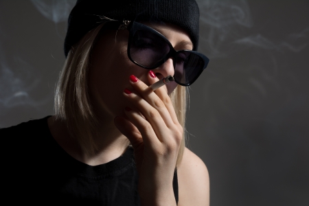 Portrait of a young girl smoking a cigarette, adolescence stress, depression habitの写真素材