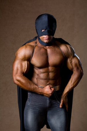 Strong muscular man in black mask and with a naked torsoの写真素材
