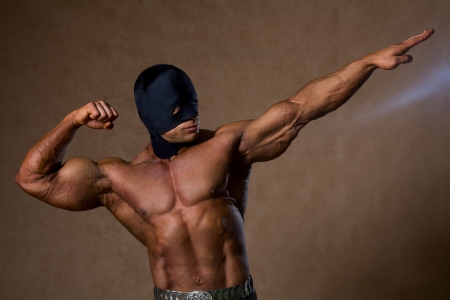 Strong muscular man in black mask and with a naked torsoの写真素材