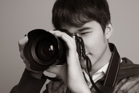 Male photographer taking photos with DSLR digital camera.の写真素材