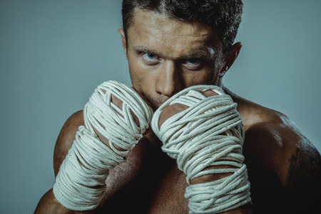 Strong man street fighter, by the hand wound rope. Desperate courageous man defender.の写真素材
