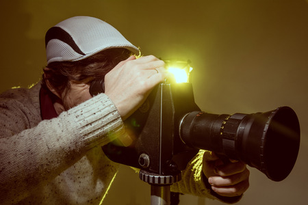 Man with old film movie camera. Shooting of the film, advertising and music videoの写真素材