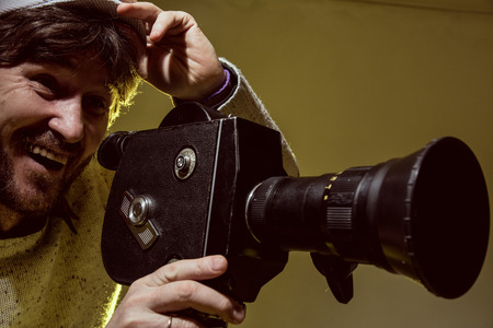 Portrait of cheerful man with a beard makes movies.の写真素材
