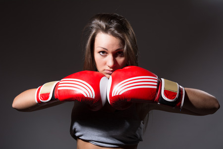 Beautiful woman with the boxing gloves,dark backgroundの写真素材