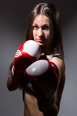 Beautiful woman with the boxing gloves,dark backgroundの写真素材