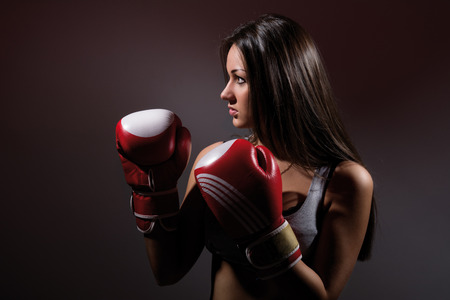 Beautiful woman with the boxing gloves,dark backgroundの写真素材