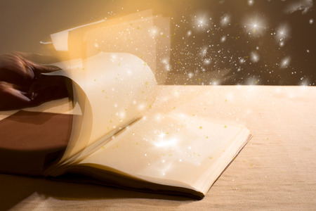 Hand leafing through a book with blank pages magic light. Educationの写真素材