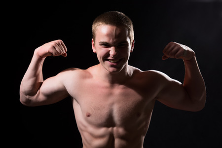 Muscular guy shows biceps. Man violently strainedの写真素材