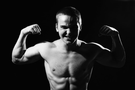 Muscular guy shows biceps. Man violently strained. monochrome imageの写真素材