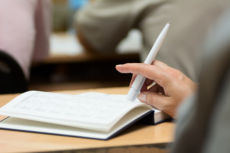 Close-up of a female hand with a pen. Hand on diary during business meetings. horizontal photoの写真素材