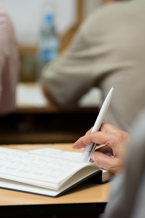 Close-up of a female hand with a pen. Hand on diary during business meetingsの写真素材
