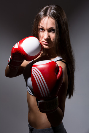 Beautiful girl with the boxing gloves,dark backgroundの写真素材