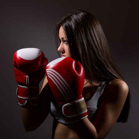 Beautiful woman with the boxing gloves,dark backgroundの写真素材