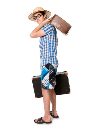 Young, handsome man in glasses with two bags ready to travel. The stereotype of a foolish novice traveler. Portrait of a traveler in a full-length isolated on white backgroundの写真素材