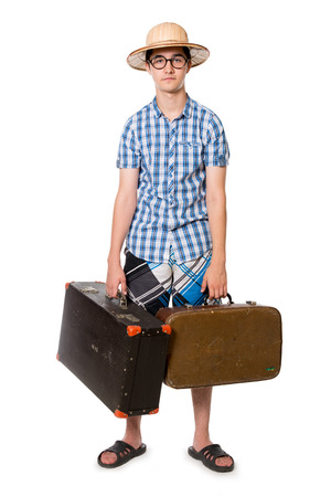 Young, handsome man in glasses with two bags ready to travel. The stereotype of a foolish novice traveler. Portrait of a traveler in a full-length isolated on white backgroundの写真素材